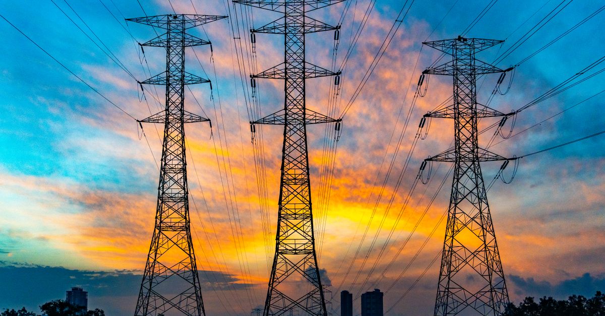 High voltage power lines against a dramatic sunset sky, symbolizing energy and technology.